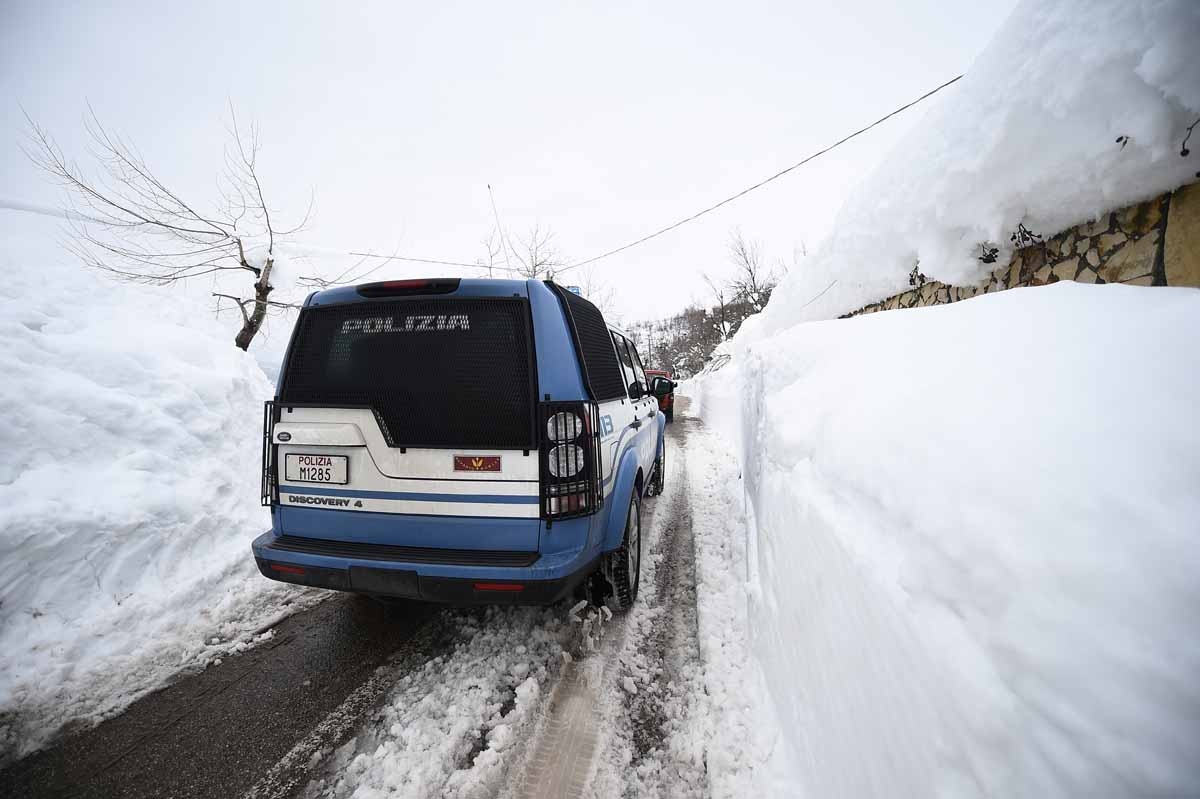 Italian police and rescuers drive through the town of Farindola as they make their way to the site of an avalanche that engulfed the Hotel Rigopiano, some 7 kilometres away, in earthquake-ravaged central Italy, on January 20, 2017.