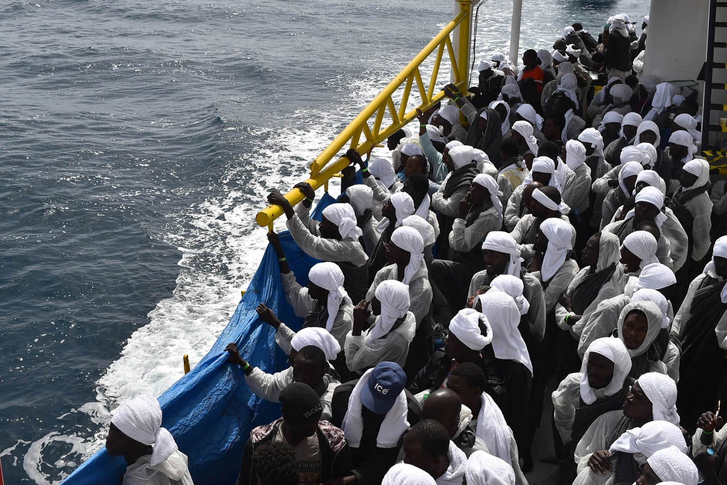 Migrants wait aboard rescue ship Aquarius as they arrive in the port of Cagliari, Sardinia, on May 26, 2016