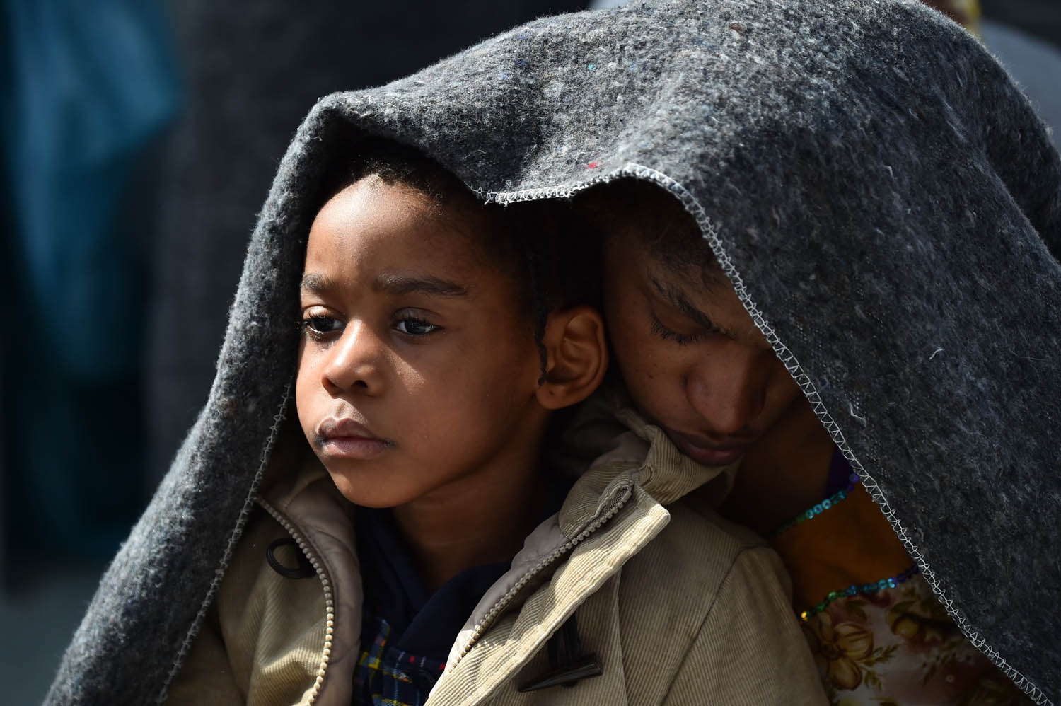 A woman and her daughter protect themselves with a blanket aboard the rescue ship Aquarius, on May 25, 2016