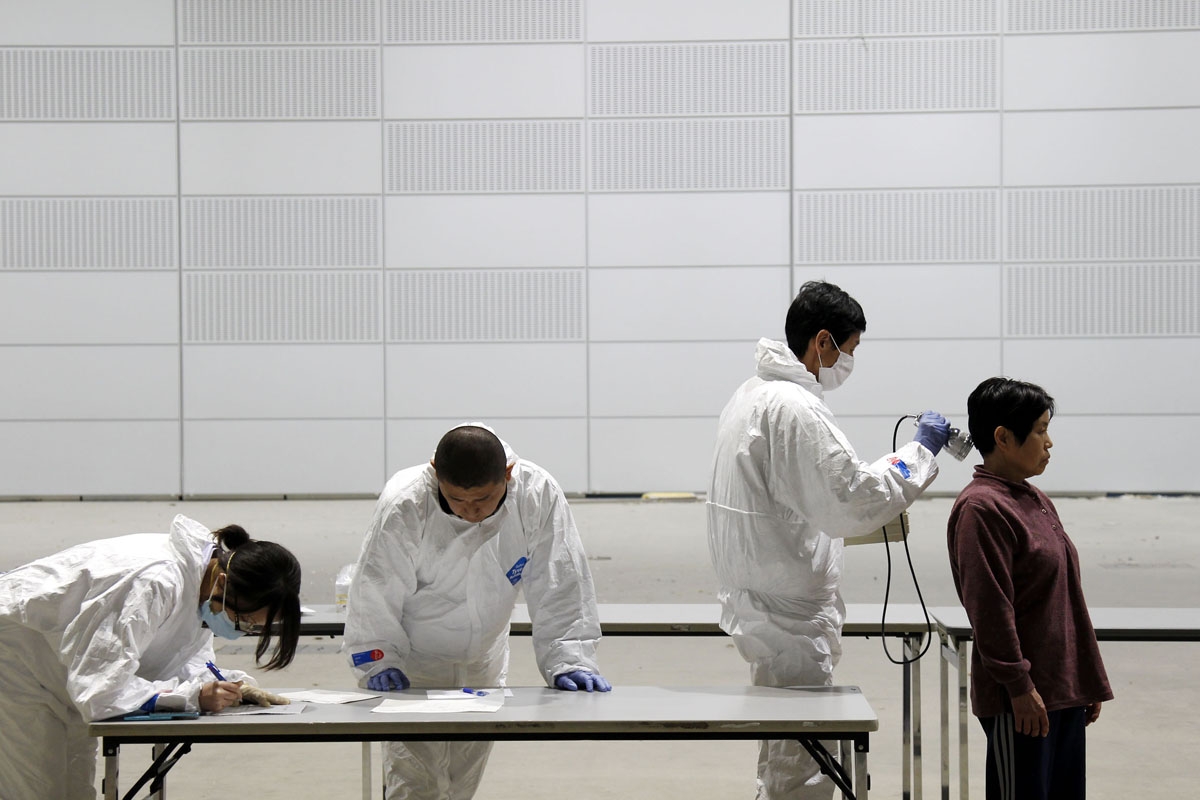 Officials scan people for radiation, 60 km west of the nuclear power plant in Fukushima prefecture, in Koriyama on March 18, 2011.