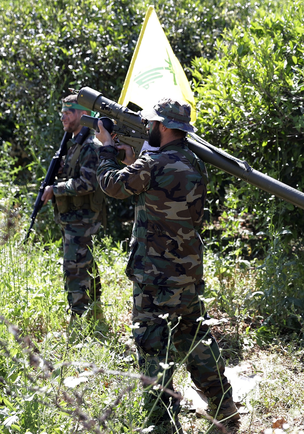 Hezbollah fighters are seen standing at attention in an orange field near the town of Naqura on the Lebanese-Israeli border on April 20, 2017.