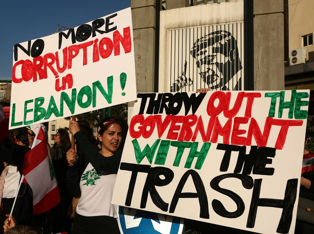 Lebanese women wave their national flag and hold placards as they take part in a protest in Beirut on March 12, 2016 against corruption and the garbage crisis