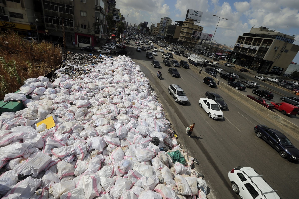 Cars drive by piles of garbage, along the Jdeideh highway, northeast of the Lebanese capital Beirut on September 23, 2016