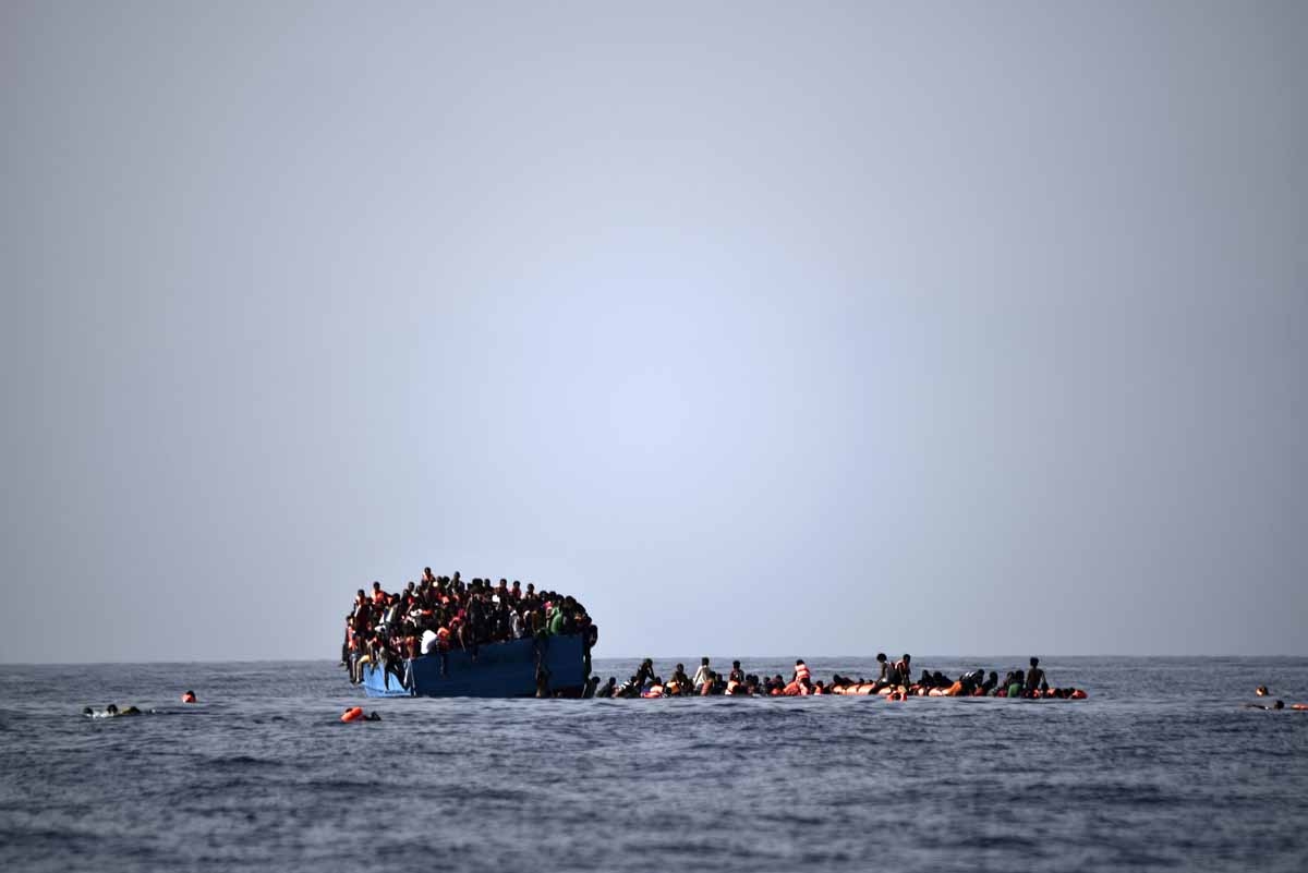 Migrants wait to be rescued by members of Proactiva Open Arms NGO in the Mediterranean Sea, some 12 nautical miles north of Libya, on October 4, 2016. Migrants wait to be rescued by members of Proactiva Open Arms NGO in the Mediterranean Sea, some 12 nautical miles north of Libya, on October 4, 2016.