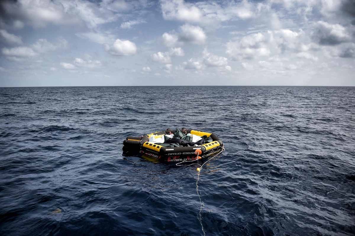 A life boat carrying the bodies of 29 refugees and migrants, who died on a rubber boat north of Libya while crossing the Mediterranean Sea, is dragged by a sailing boat of the Spanish NGO Proactiva Open Arms on October 5, 2016. A life boat carrying the bodies of 29 refugees and migrants, who died on a rubber boat north of Libya while crossing the Mediterranean Sea, is dragged by a sailing boat of the Spanish NGO Proactiva Open Arms on October 5, 2016.