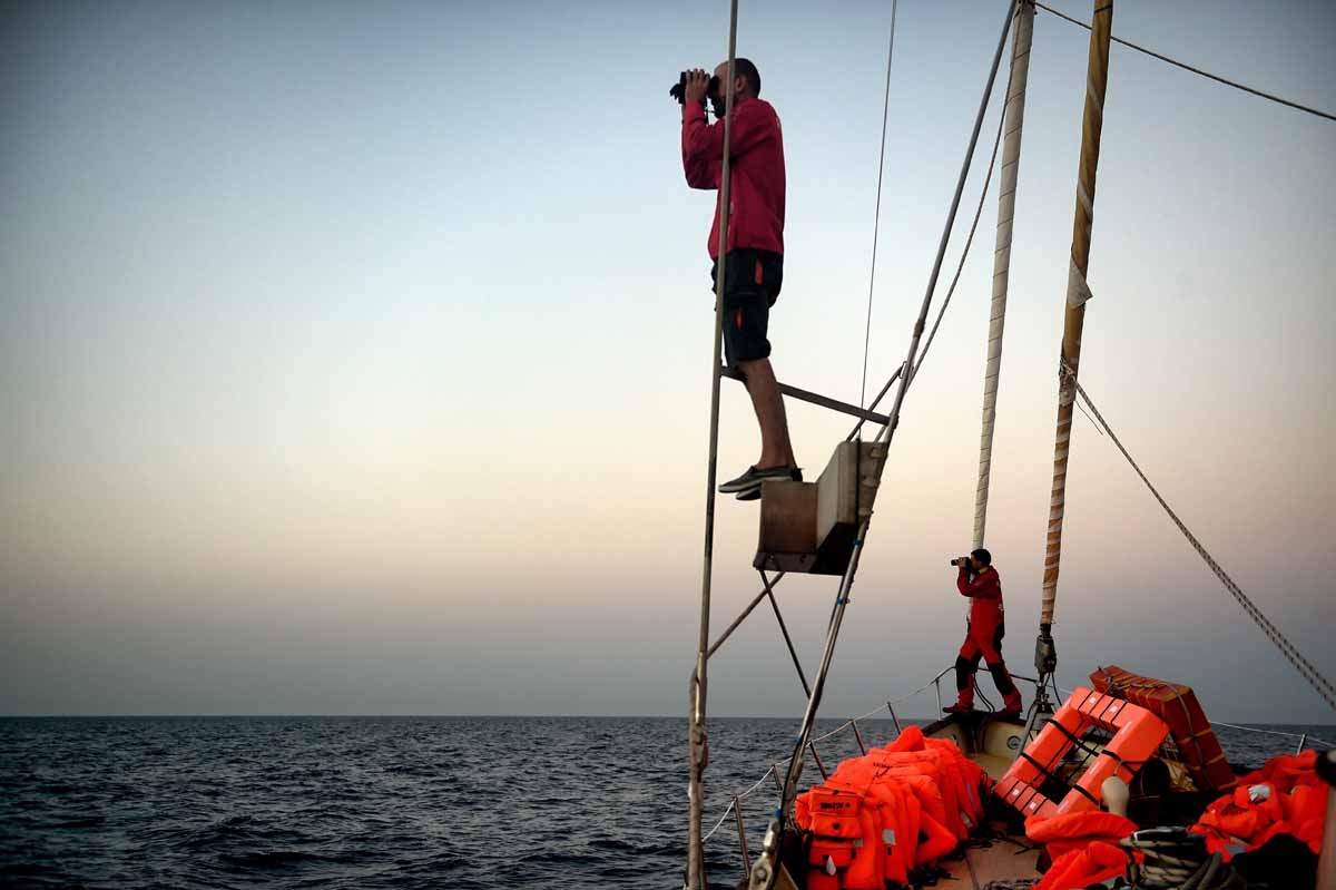 Member of Spanish humanitarian NGO Proactiva Open Arms, Savas Kourepinis (L) and Guillermo Canardo use binoculars to look for boats carrying refugees and migrants as they stand on the sailing boat Astral off the coast Libya on October 12, 2016. Member of Spanish humanitarian NGO Proactiva Open Arms, Savas Kourepinis (L) and Guillermo Canardo use binoculars to look for boats carrying refugees and migrants as they stand on the sailing boat Astral off the coast Libya on October 12, 2016.