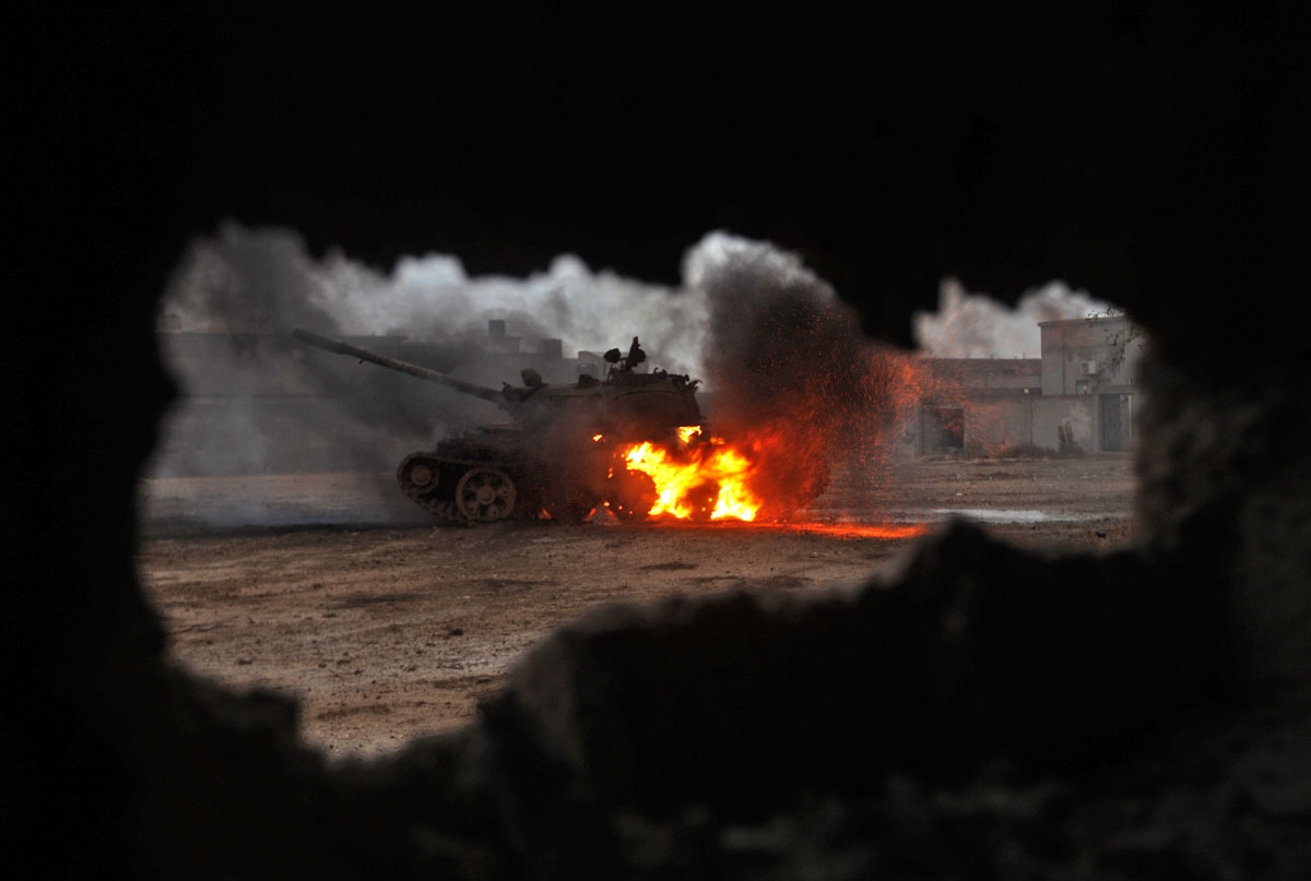 A tank is seen afire during clashes between soldiers from the Libyan National Army, led by Marshal Khalifa Haftar, and jihadist fighters on November 30, 2016 in the area of Qanfudah, south of Benghazi.