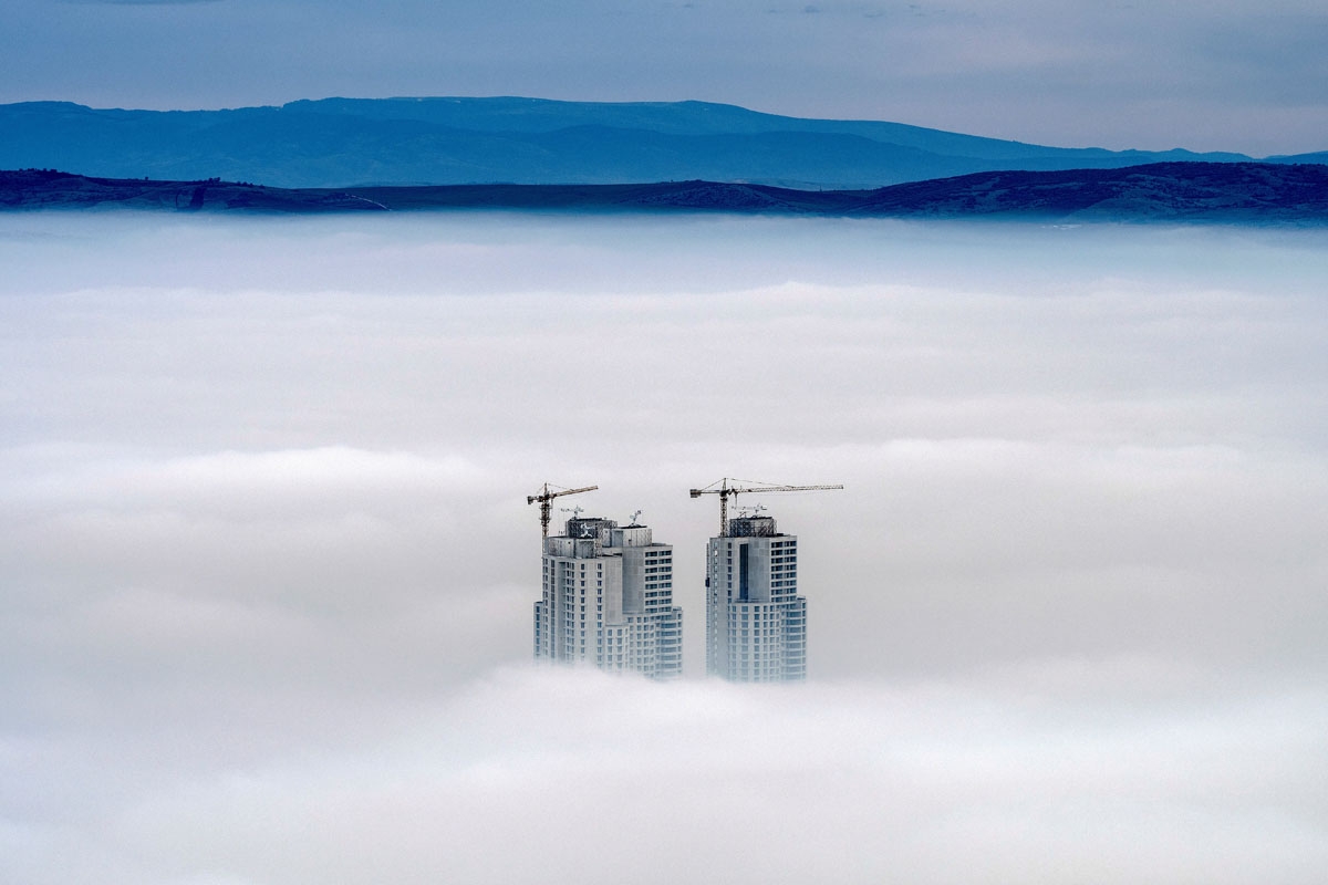 A picture taken from Vodno Mountain shows the tops of some of the city's highest buildings above clouds in an area with a high level of air pollution in Skopje on December 15, 2017.