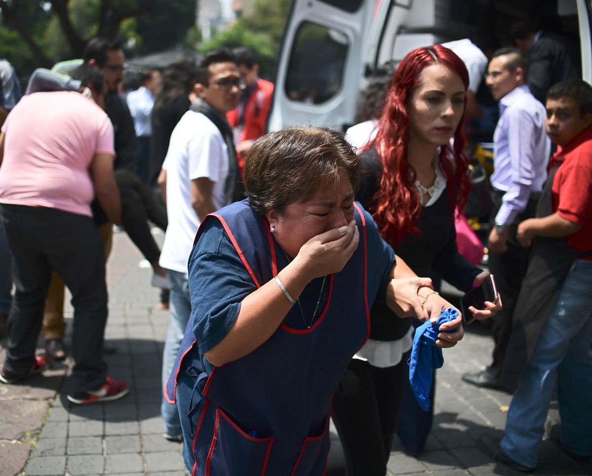 People react after a real quake rattled Mexico City on September 19, 2017 moments after an earthquake drill was held in the capital.