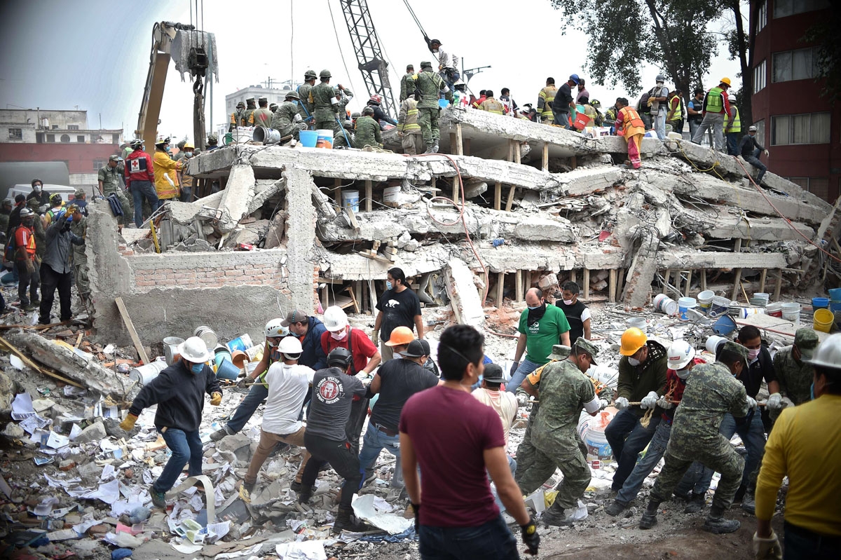 Rescuers, firefighters, policemen, soldiers and volunteers search for survivors in a flattened building in Mexico City on September 20, 2017 a day after a strong quake hit central Mexico. A powerful 7.1 earthquake shook Mexico City on Tuesday, causing pan