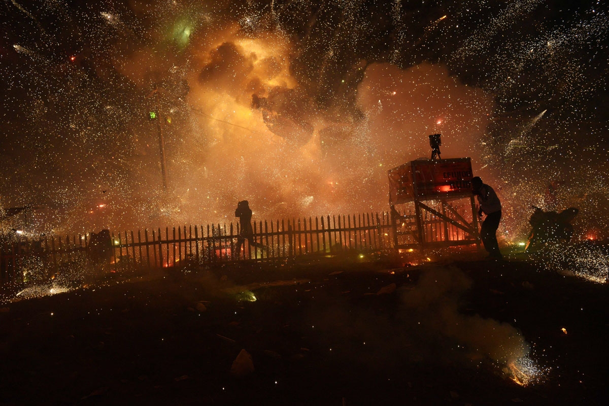 This picture taken on November 25, 2012 shows people protecting themselves from fireworks which accidentally exploded before the balloon carrying them took enough height during the hot-air balloons festival in Taunggyi in Myanmar's northeastern Shan state