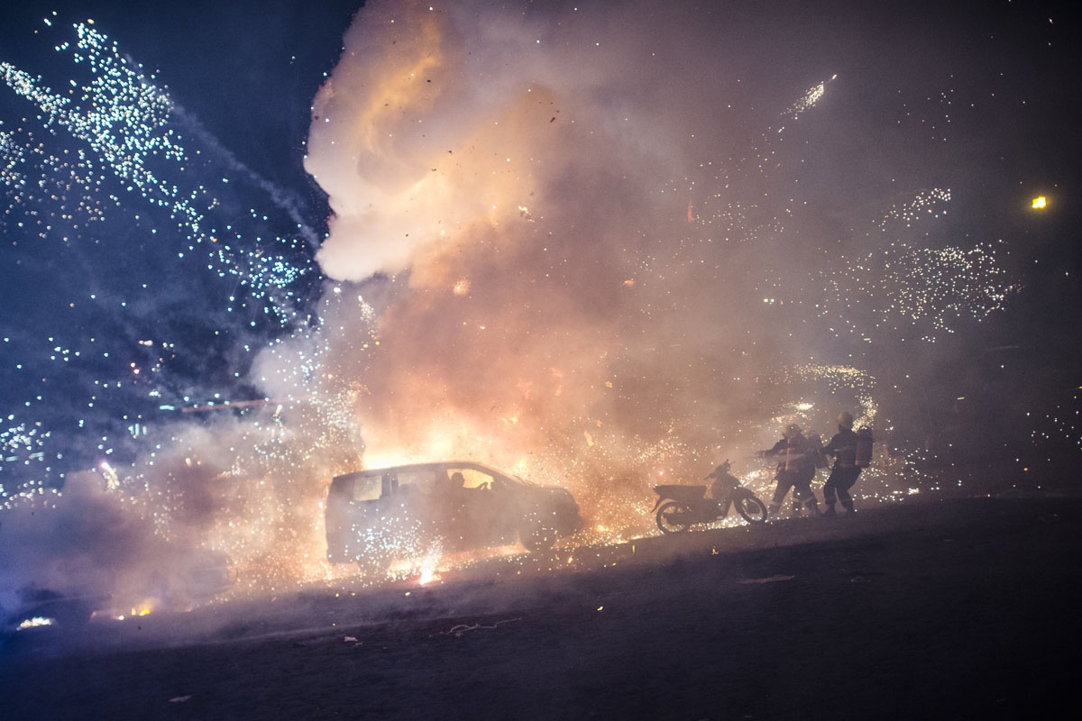 Firefighters work after a fireworks-laden hot-air balloon ignited near a car before the balloon had reached a sufficient height during the closing ceremony of the Tazaungdaing Festival at Taunggyi, in Myanmar's northeastern Shan State, on November 15, 201
