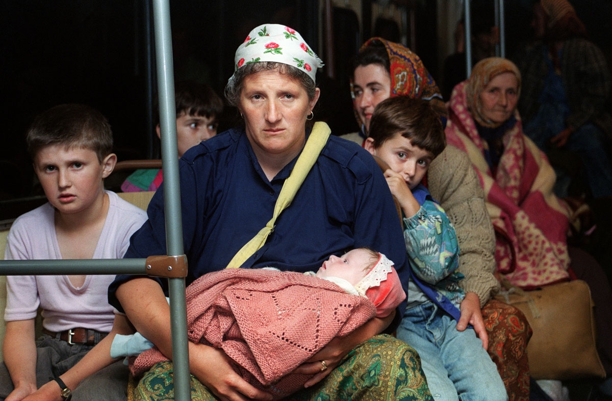 Women and children evacuees sit in a bus on July 26 1995 as they are driven by Bosnian Serbs from the fallen enclave of Zepa without UN escorts to the frontline crossing point close to the government held town of Klandanj. A UN convoy of armoured ambulanc