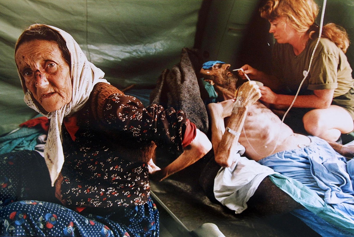 A picture taken on July 11, 1995 shows an elderly Muslim woman and her husband getting treatment for injuries inflicted on them by Serb military forces as they fled the east Bosnian enclave of Srebrenica. A