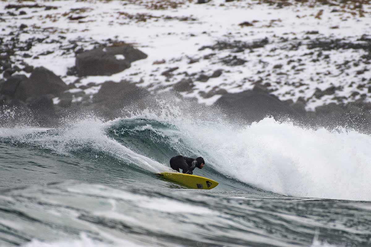 Australian surf legend from the 80's Tom Carroll, 55, rides a radical frontside cut-back wave in Unstad above the Arcic Circle on March 12, 2017. / AFP PHOTO / OLIVIER MORIN