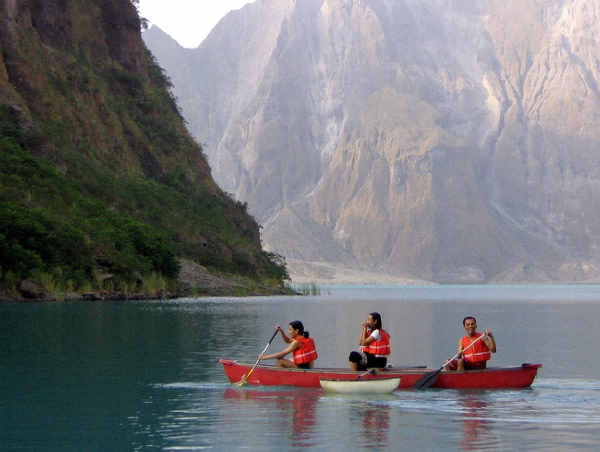Local tourists use a kayak to explore the turquoise-colored crater lake of Mount Pinatubo volcano 29 April 2006. Local tourists use a kayak to explore the turquoise-colored crater lake of Mount Pinatubo volcano 29 April 2006.
