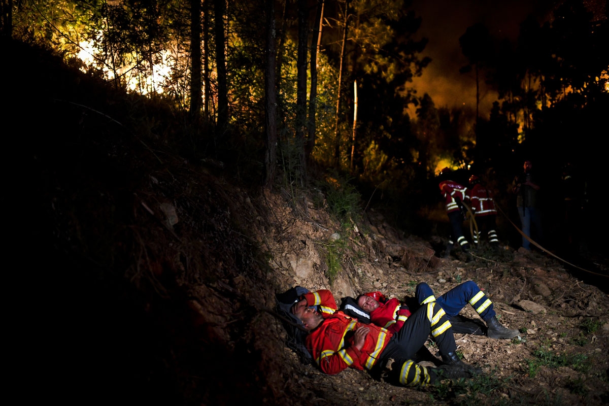 Firefighters rest during a wildfire at Penela, Coimbra, central Portugal, on June 18, 2017.