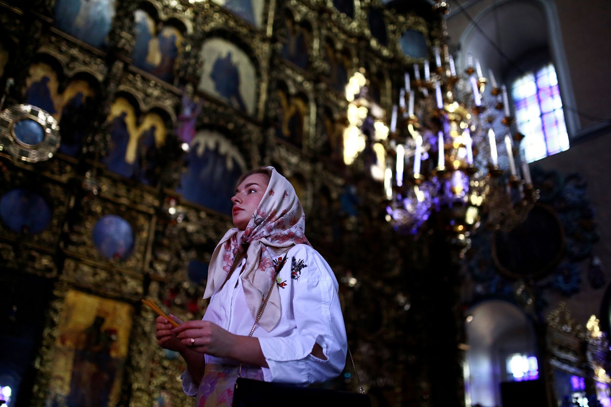 A woman gives a prayer in the Saint Peter and Saint Paul church in Kazan on June 18, 2018, during the Russia 2018 World Cup football tournament. / AFP PHOTO / Benjamin CREMEL