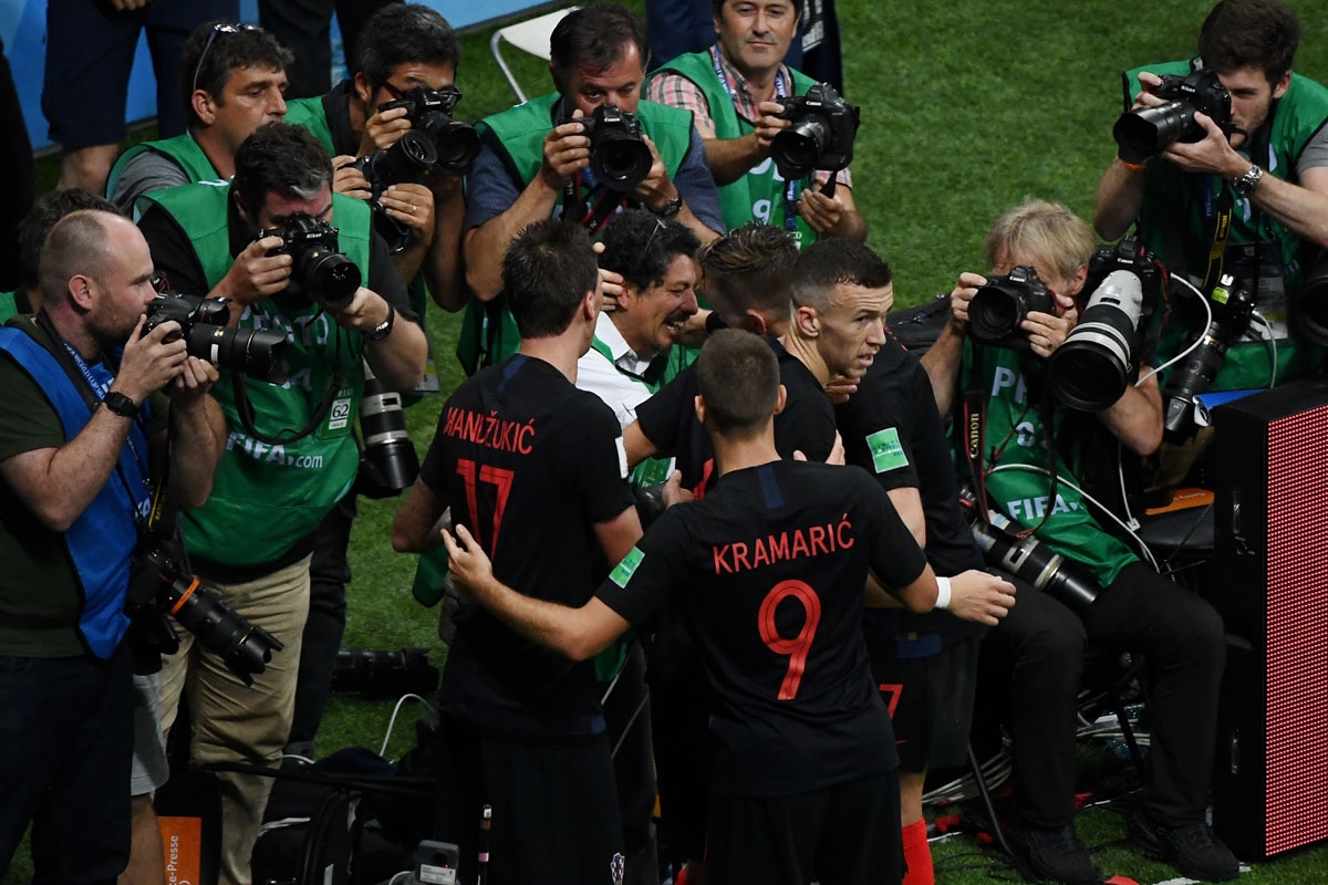 Croatia's forward Mario Mandzukic (C-L) and Croatia's midfielder Ivan Rakitic (C2R) speak to AFP photographer Yuri Cortez (C) after falling on him with teammates while celebrating their second goal during the Russia 2018 World Cup semi-final football matc