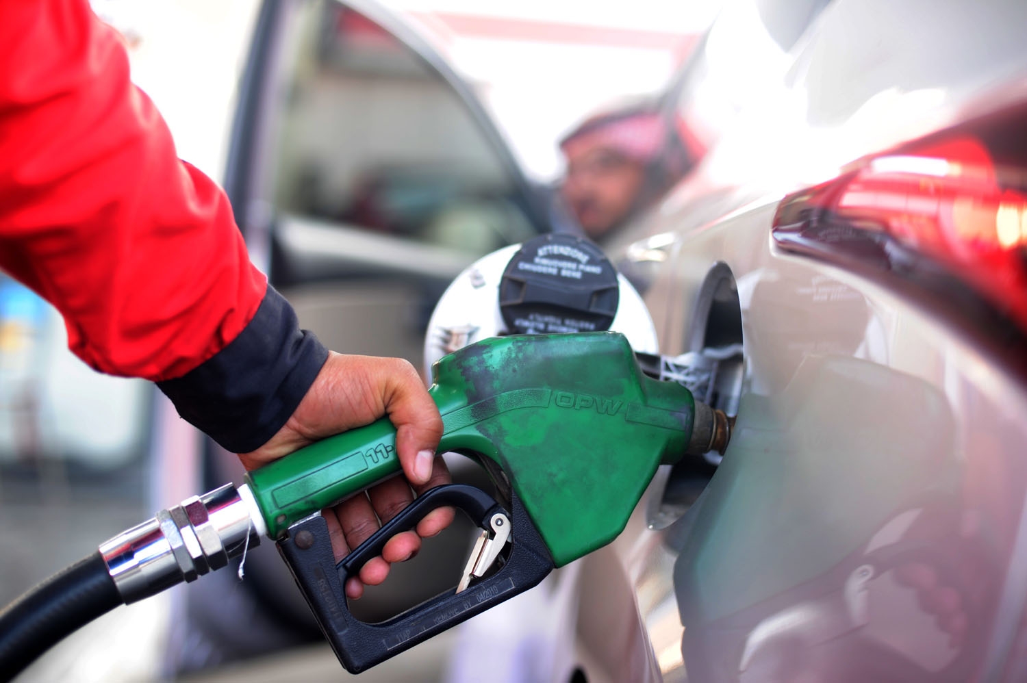A Saudi employee fills the tank of his car with petrol at a station on December 28, 2015 in the Red Sea city of Jeddah. Saudi-royal-media