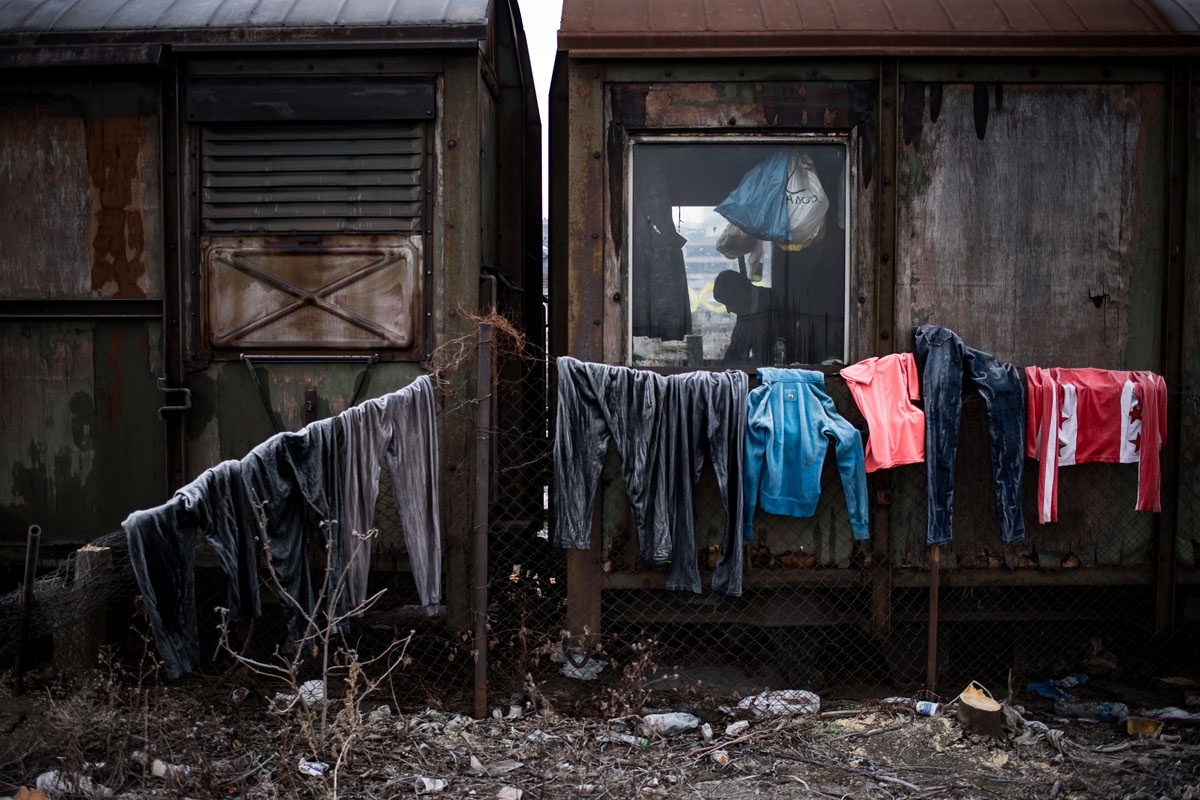 A migrant is seen inside of an abandoned train wagon used as a makeshift shelter near Belgrade's main railway station on January 16, 2017, with temperatures just bellow zero Celsius overnight.