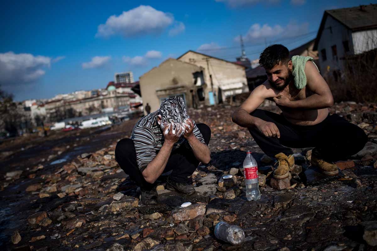 Migrants wash themselfs outside of derelict warehouses which they use as a makeshift shelter in Belgrade on January 15, 2017, with temperatures just bellow zero Celsius overnight.