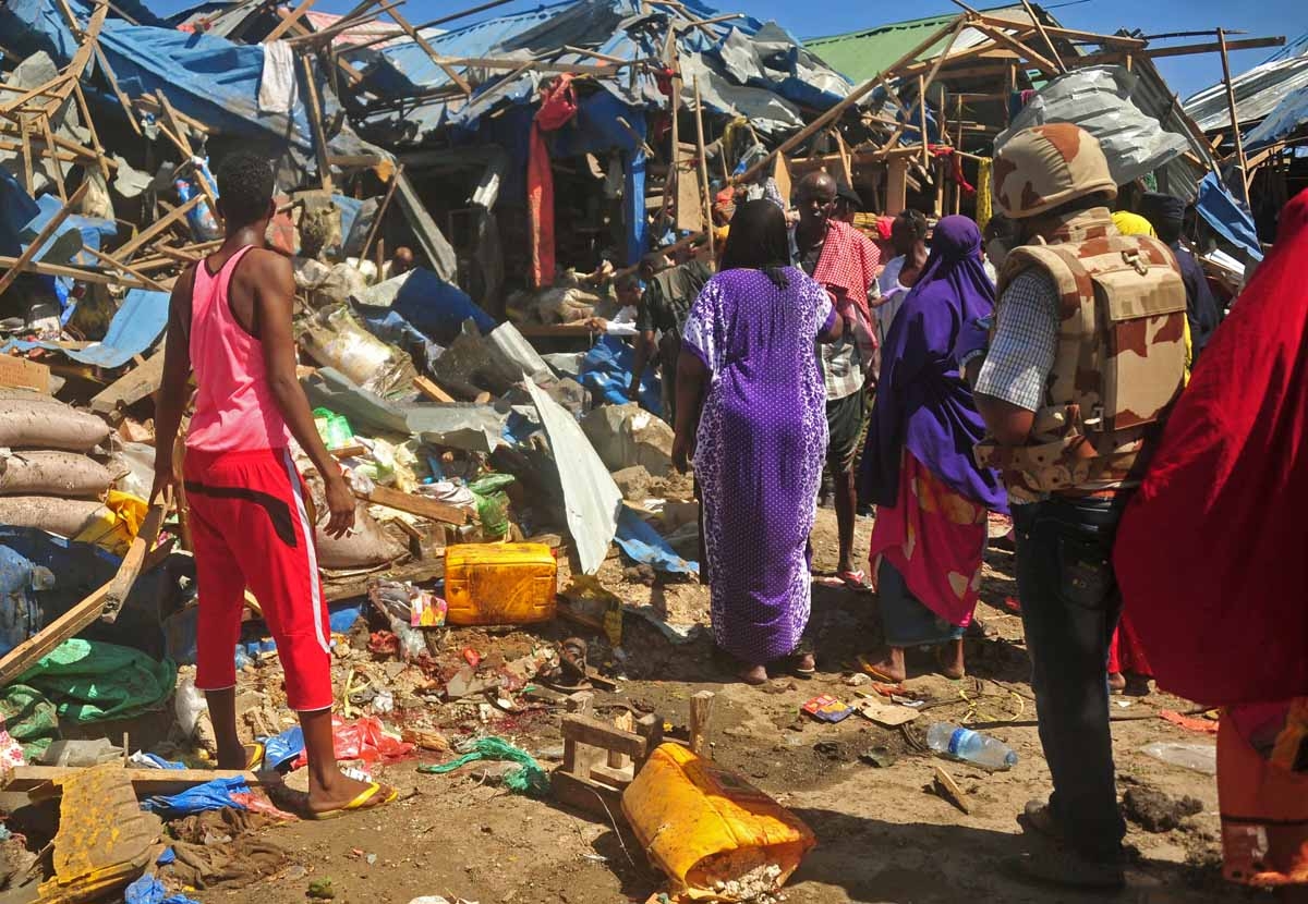 Residents gather, on November 26, 2016, at the scene of a suicide car bomb attack in Somalia's restive capital, Mogadishu.