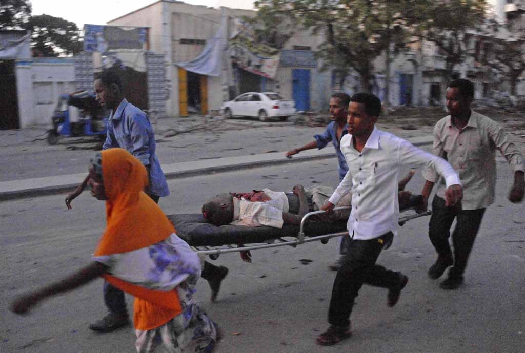 People carry a victim of a terror attack at the Ambassador Hotel, after Somalia's Al-Qaeda-linked Shabaab on June 1, 2016, launched a deadly attack on a top Mogadishu hotel popular with MPs, setting off a car bomb and fighting security forces inside the c People carry a victim of a terror attack at the Ambassador Hotel, after Somalia's Al-Qaeda-linked Shabaab on June 1, 2016, launched a deadly attack on a top Mogadishu hotel popular with MPs, setting off a car bomb and fighting security forces inside the c