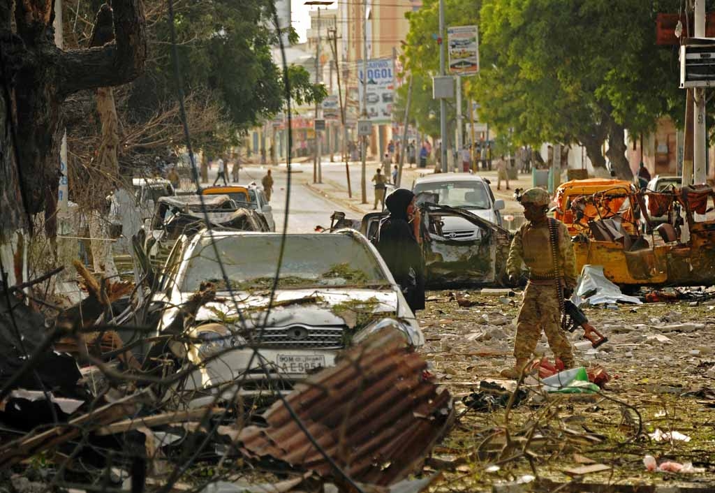 A woman stands next to a military on the scene of a terror attack on the Ambassador Hotel claimed by Somalia's Al-Qaeda-linked Shabaab, in Mogadishu on June 2, 2016. A woman stands next to a military on the scene of a terror attack on the Ambassador Hotel claimed by Somalia's Al-Qaeda-linked Shabaab, in Mogadishu on June 2, 2016.