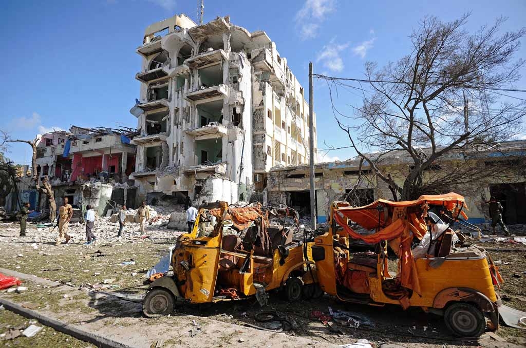 People stand on the scene of a terror attack outside The Ambassador Hotel in Mogadishu on June 2, 2016. People stand on the scene of a terror attack outside The Ambassador Hotel in Mogadishu on June 2, 2016.