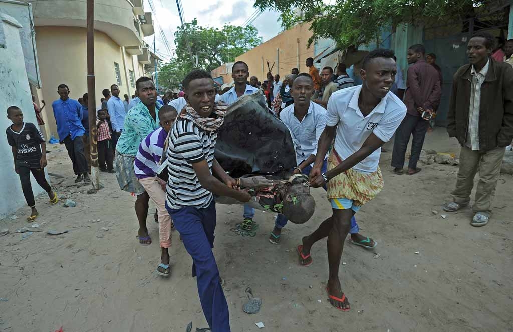 People carry the body of a civilian victim from the scene of a terror attack outside The Ambassador Hotel in Mogadishu on June 2, 2016. People carry the body of a civilian victim from the scene of a terror attack outside The Ambassador Hotel in Mogadishu on June 2, 2016.