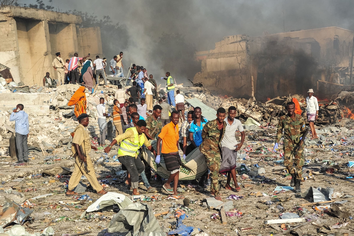 Men and Somalian soldiers rescue victims on the site of the explosion of a truck bomb in the centre of Mogadishu, on October 14, 2017.