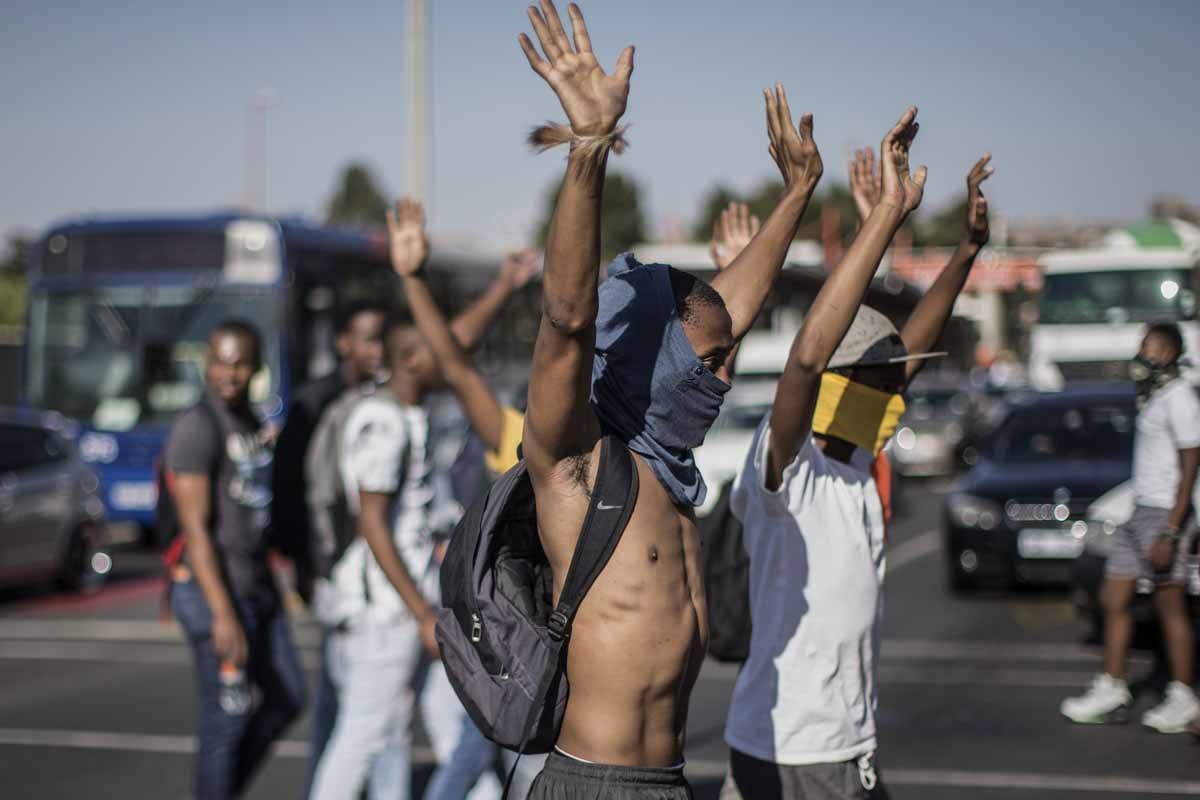 University of Johannesburg students raise their hands while blocking a motorway during clashes with riot police on September 28, 2016 outside the University of Johannesburg Campus. University of Johannesburg students raise their hands while blocking a motorway during clashes with riot police on September 28, 2016 outside the University of Johannesburg Campus.