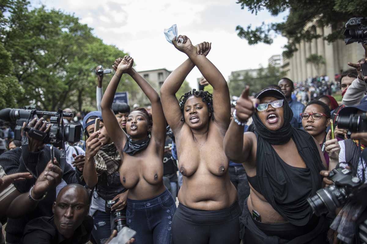 Bare chest students gesture at the University of Witwatersrand in Johannesburg on October 4, 2016 in an act of defiance against South African anti riot policemen during a mass demonstration. Bare chest students gesture at the University of Witwatersrand in Johannesburg on October 4, 2016 in an act of defiance against South African anti riot policemen during a mass demonstration.