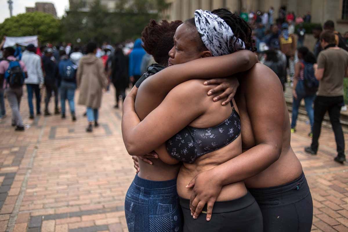 Three students hug at the University of Witwatersrand in Johannesburg on October 4, 2016 during a mass protest of the Fees Must Fall movement. Three students hug at the University of Witwatersrand in Johannesburg on October 4, 2016 during a mass protest of the Fees Must Fall movement.