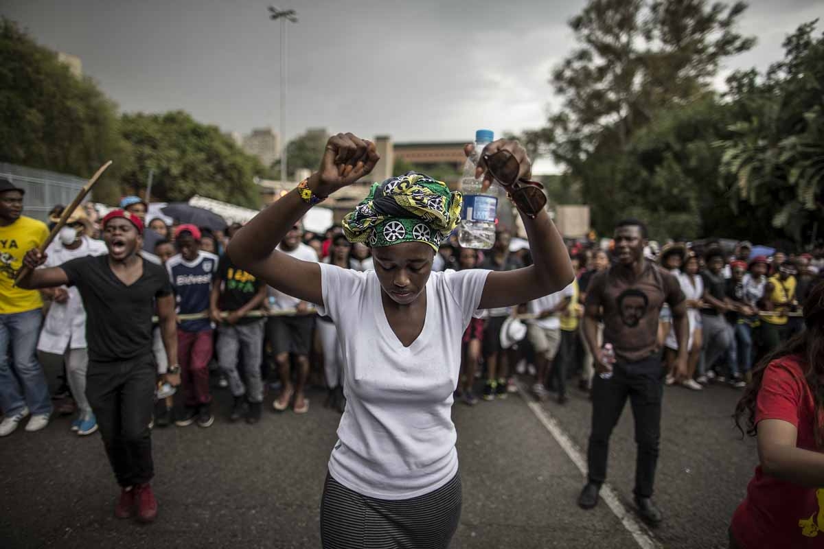 A young woman holds up her fists as students march through the campus of the University of the Witwatersrand in Johannesburg on October 21, 2015, during a protest against fee hikes. A young woman holds up her fists as students march through the campus of the University of the Witwatersrand in Johannesburg on October 21, 2015, during a protest against fee hikes.