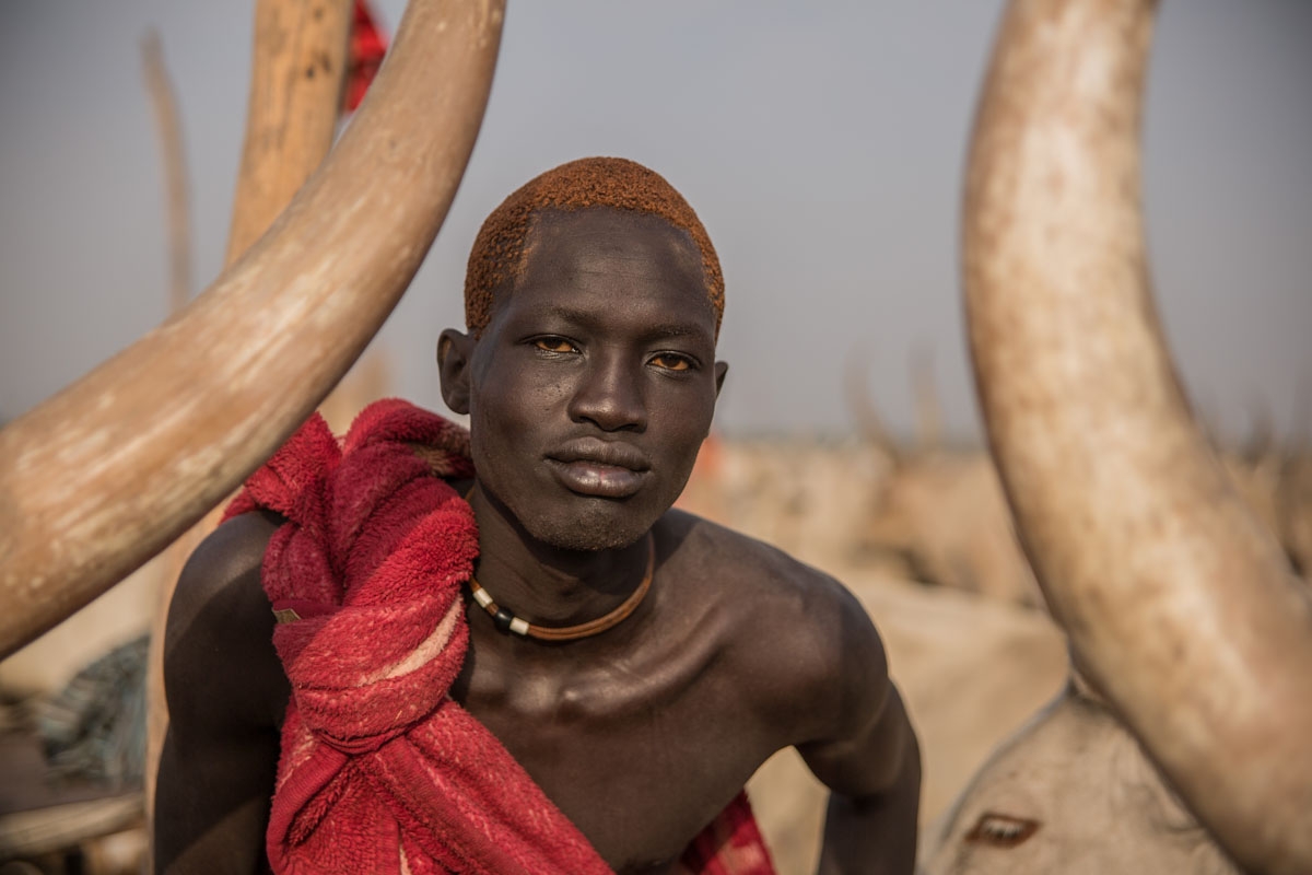 A Sudanese man from Dinka tribe shows his orange hair bleached by cow's urine at their cattle camp in Mingkaman, Lakes State, South Sudan, on March 3, 2018.