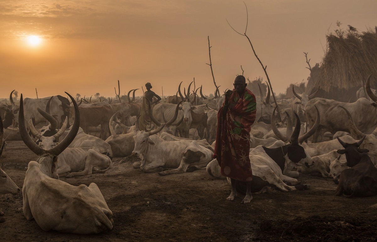 A Sudanese man from Dinka tribe stands in the early morning at their cattle camp in Mingkaman, Lakes State, South Sudan, on March 3, 2018.