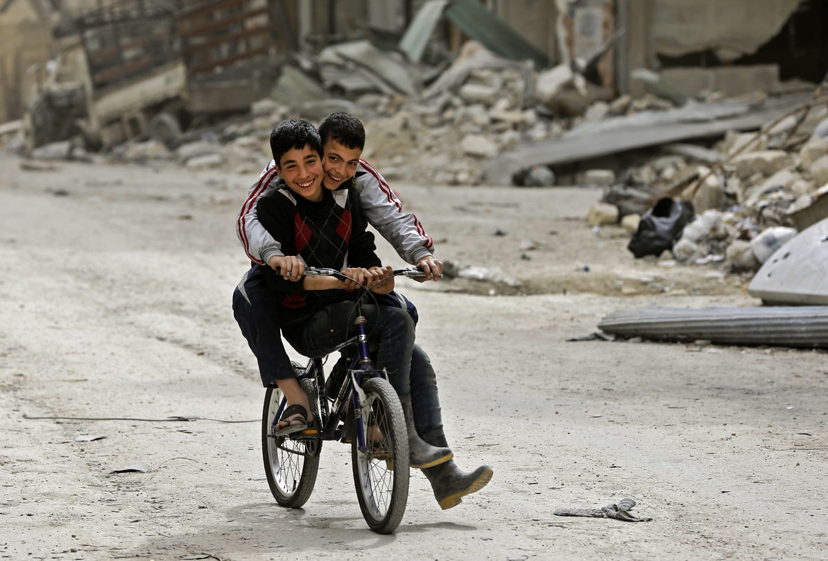 Syrian children play in the once rebel-held Shaar neighbourhood in the northern city of Aleppo on March 10, 2017. / AFP PHOTO / JOSEPH EID