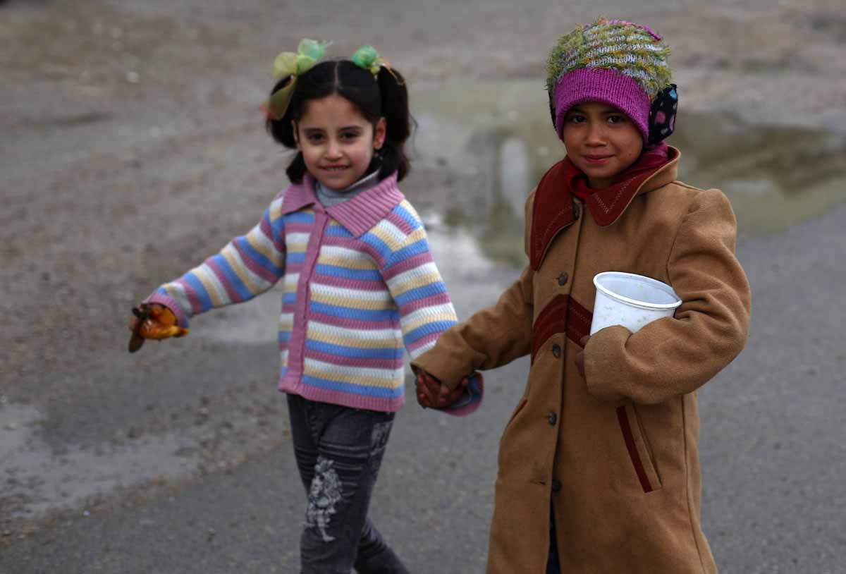 Young Syrian girls walk in a street on March 21, 2015 in the rebel-held area of Douma, east of the capital Damascus.