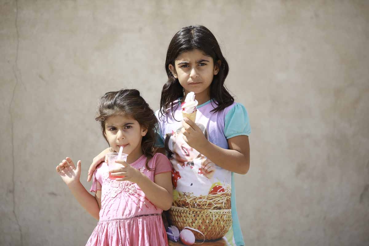 Syrian girls pose for a photograph as they stand on a street in the Kurdish-majority northeastern city of Qamishli on September 16, 2016.