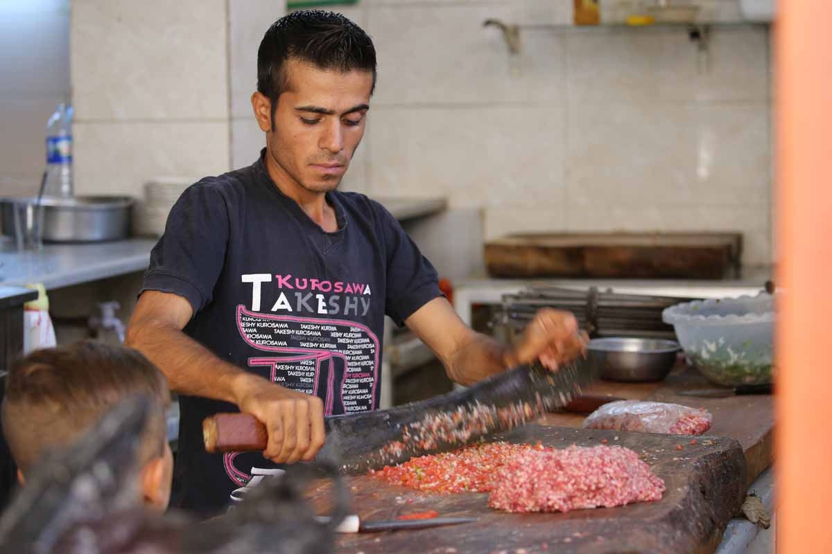A Syrian man prepares food at a shop in the Kurdish-majority northeastern city of Qamishli on September 16, 2016.