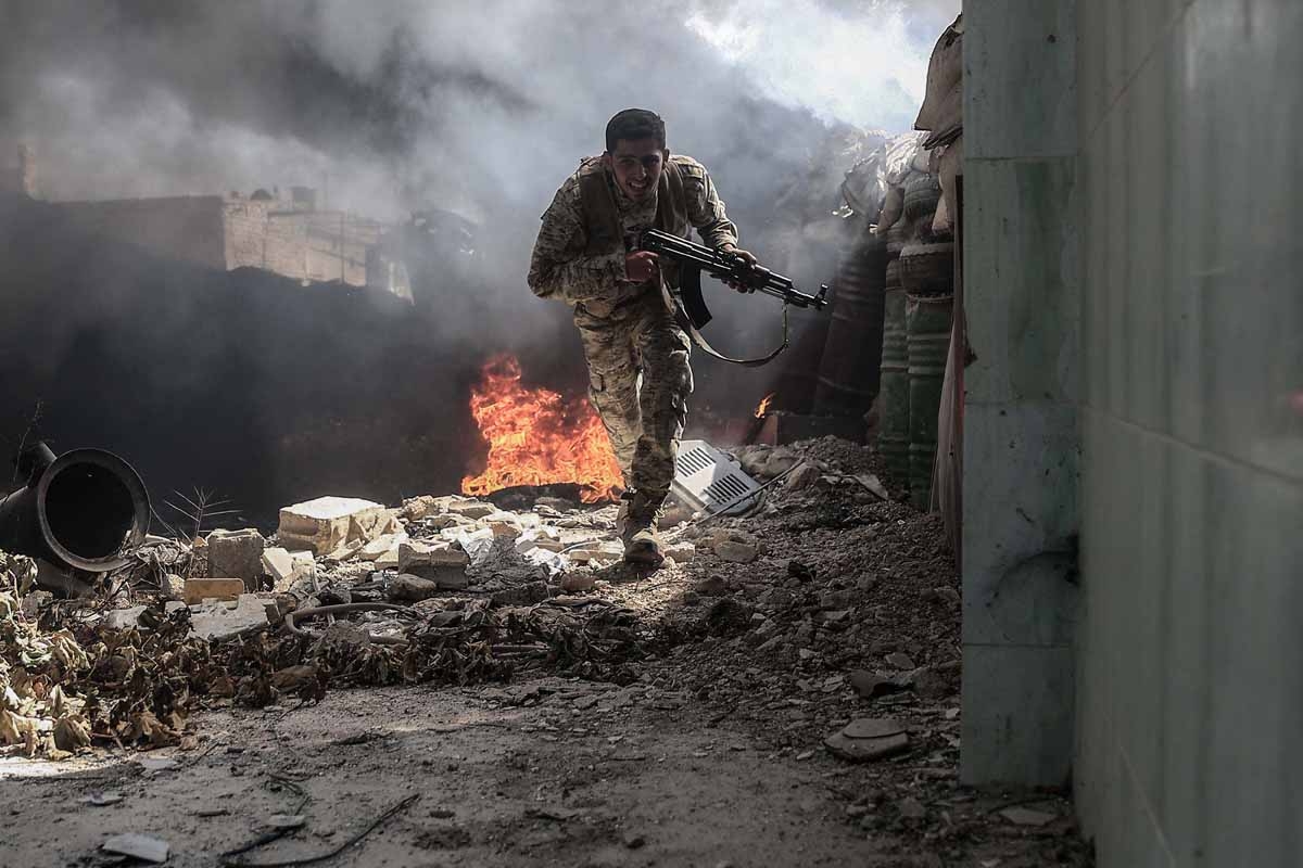 A fighter from the Jaish al-Islam (Islam Army) runs to avoid sniper fire, in the village of Tal al-Siwan area of the rebel-held stronghold of Douma, on the outskirts of Damascus, on September 5, 2016.