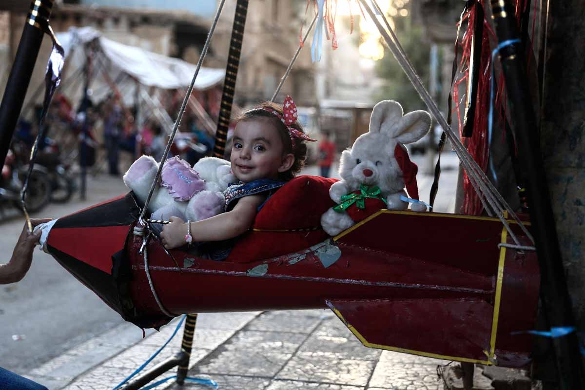 A Syrian child plays on a swing, made from the remnants of exploded rockets in the rebel-held town of Douma, on the eastern edges of the capital Damascus, on September 14, 2016, on the third day of Eid al-Adha Muslim holiday.