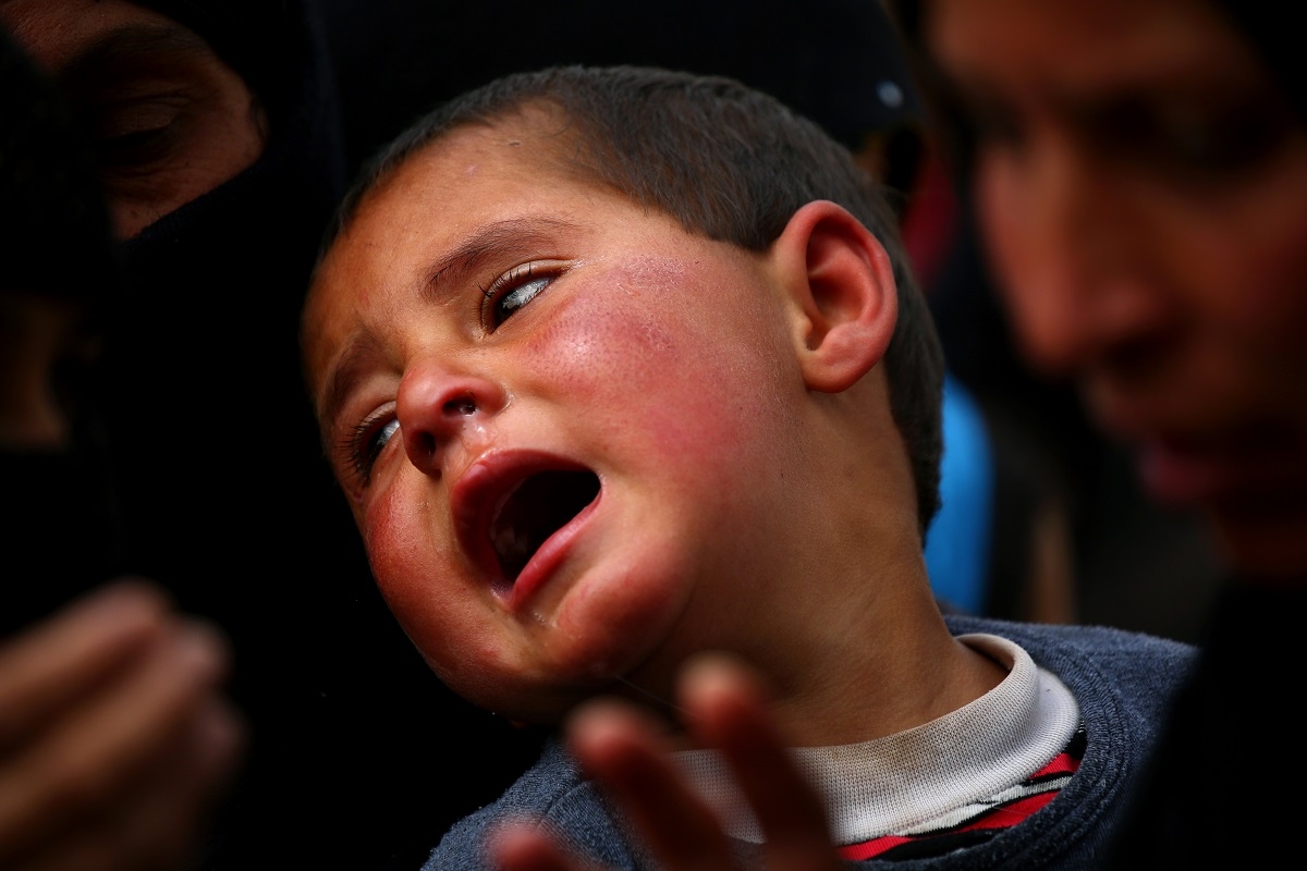 A boy reacts as displaced Syrians from Tabqa and Raqa, who fled the fighting between the US-backed Syrian Democratic Forces and Islamist State group jihadists, wait for receiving aid parcels near the northern Syrian village of Jarniyah, on April 6, 2017.