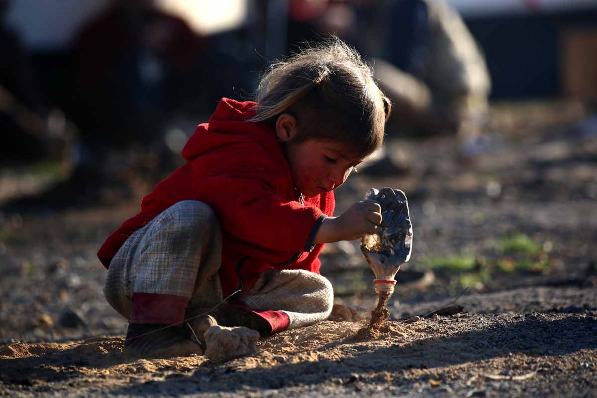 A Syrian child plays with dirt at a temporary refugee camp in the village of Ain Issa, housing people who fled Islamic State group's Syrian stronghold Raqa, some 50 kilometres (30 miles) north of the group's de facto capital on March 25, 2017.