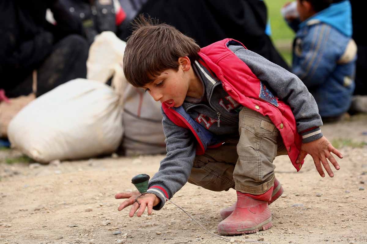 A displaced Syrian boy, who fled the Islamic State (IS) group stronghold of Raqa, plays as he arrives at a temporary camp in the village of Ain Issa on March 31, 2017.