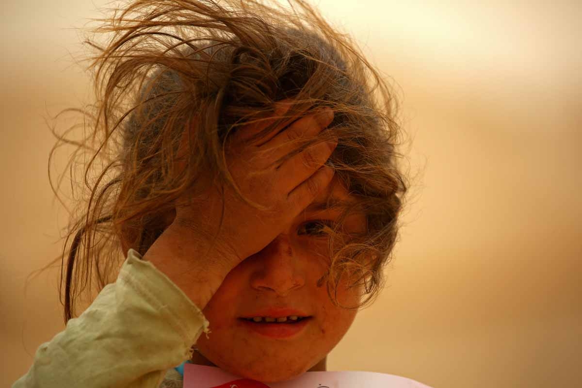 A displaced Syrian girls looks on at the al-Mabrouka camp in the village of Ras al-Ain on the Syria-Turkey border, where many Syrians who fled from territory held by the Islamic State (IS) group in Deir Ezzor and Raqa are taking shelter on April 23, 2017.