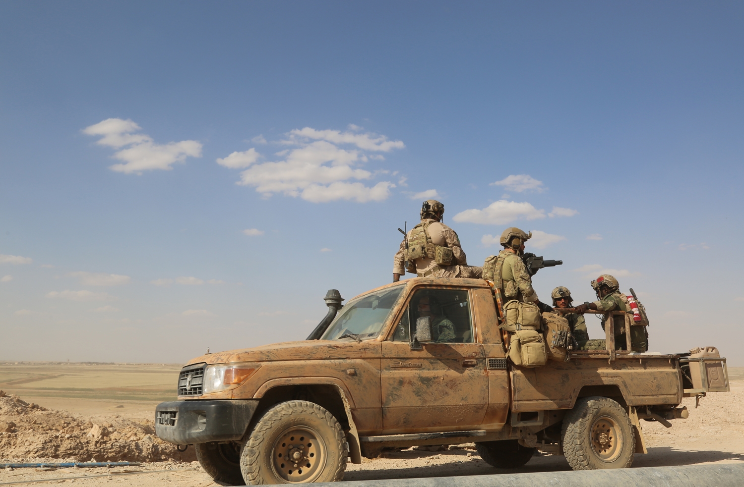 Armed men in uniform identified by Syrian Democratic forces as US special operations forces ride in the back of a pickup truck in the village of Fatisah in the northern Syrian province of Raqa on May 25, 2016. Armed men in uniform identified by Syrian Democratic forces as US special operations forces ride in the back of a pickup truck in the village of Fatisah in the northern Syrian province of Raqa on May 25, 2016.
