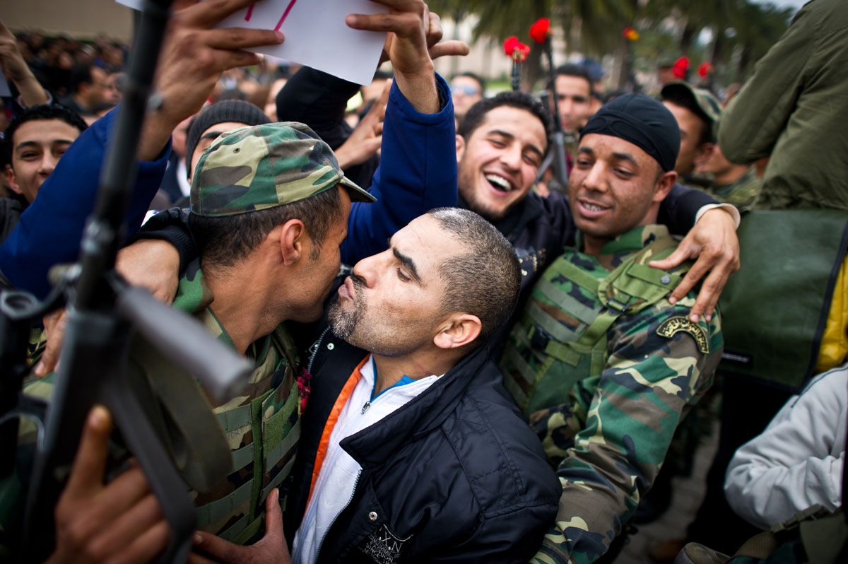 Protestors kiss soldiers during a demonstration against Ben Ali's Constitutional Democratic Rally (RCD) in a new wave of anger about the presence of RCD stalwarts in the transitional government, on January 20, 2011, in Tunis.
